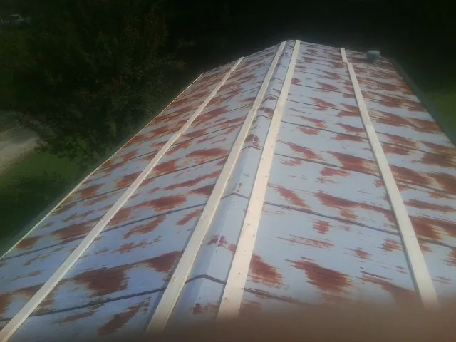 Rusted metal roof panels with new wood purlins before replacement — Storm Damage Roof Repair in Bonsall by Roofing Brothers