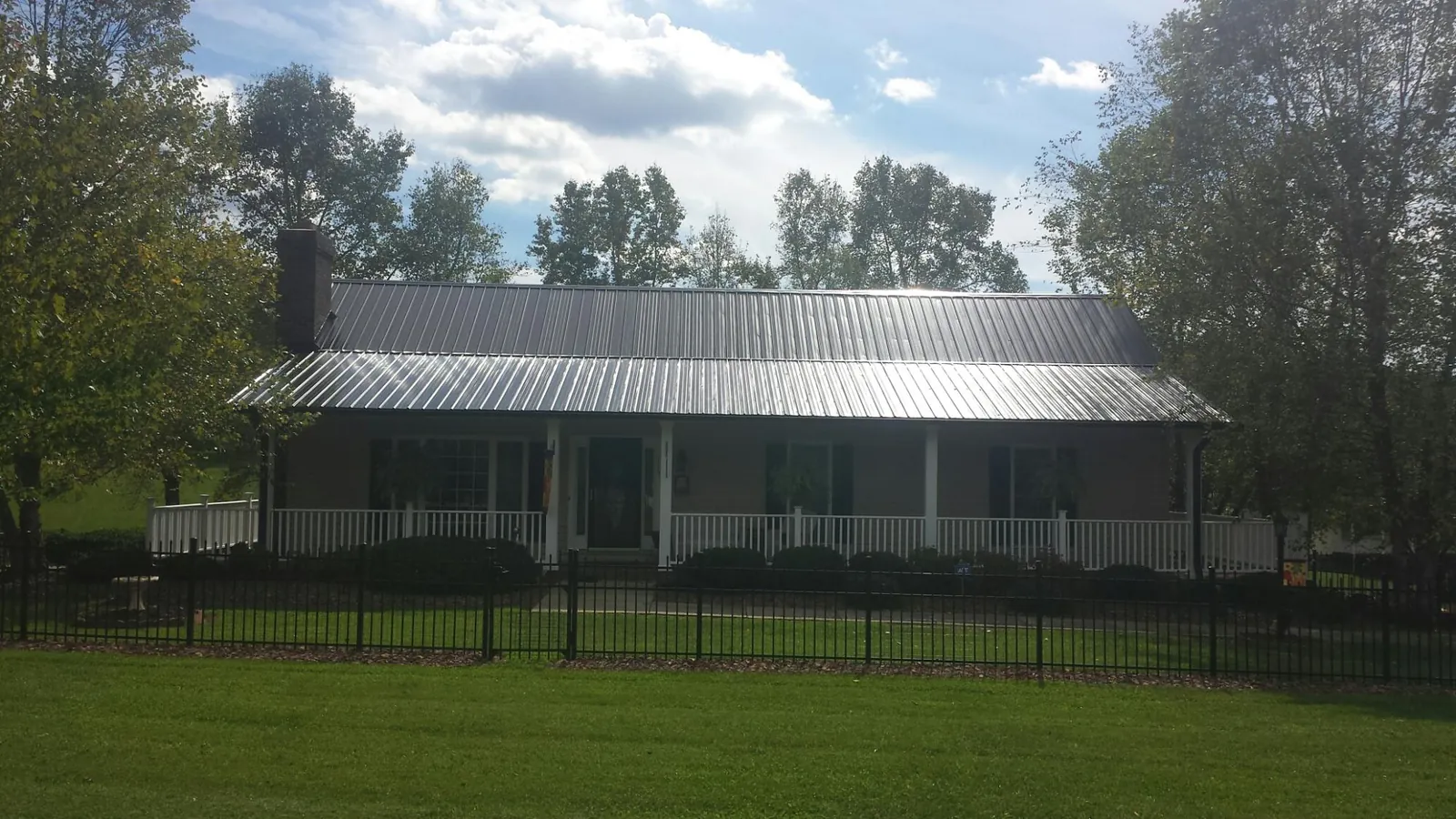 Gray metal roof on a brick ranch with a full width front porch — Gutter Guard Installation work by our crew in Bonsall
