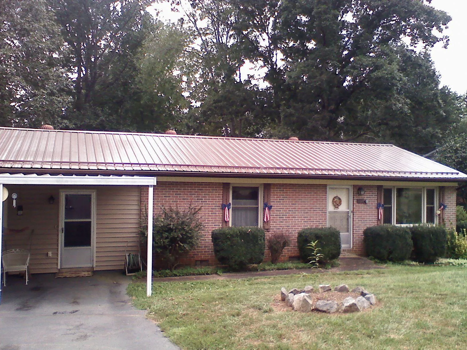 Bronze metal roof and carport on a brick ranch home — Roof Repair work by our crew in Bonsall